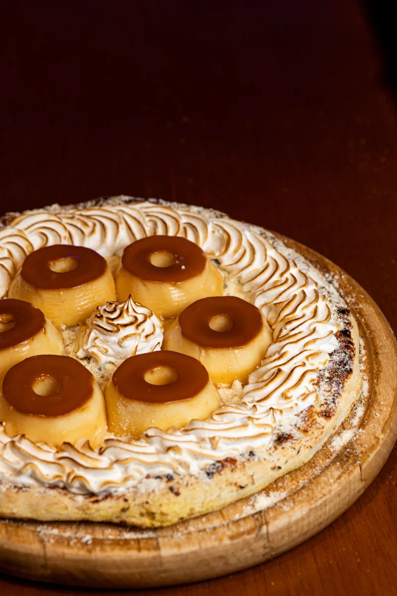 Pizza de Pudim com rodelas de pudim e merengue maçaricado, na tábua